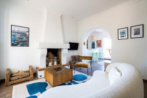 a living room with a white couch and a fireplace at VILLA AMPHITRITE, SAINT TROPEZ in Saint-Tropez