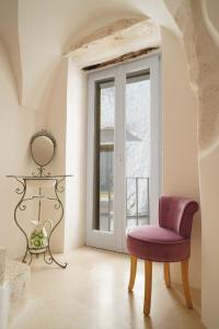 una silla roja en una habitación con ventana en Blu_Cielo Terra en Ostuni