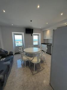 a living room with a table and chairs and a kitchen at Apartamento vista al Puerto de Finisterre in Fisterra