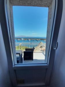 a view of the ocean from a window at Apartamento vista al Puerto de Finisterre in Fisterra