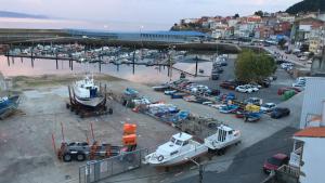 an aerial view of a harbor with cars and a boat at Apartamento vista al Puerto de Finisterre in Fisterra