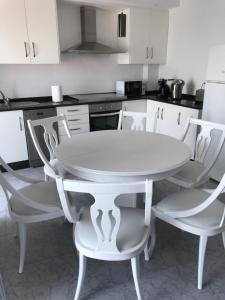 a white table and chairs in a kitchen at Apartamento vista al Puerto de Finisterre in Fisterra