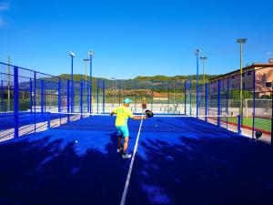 a man is standing on a tennis court at Futura Club La Praya in Pizzo