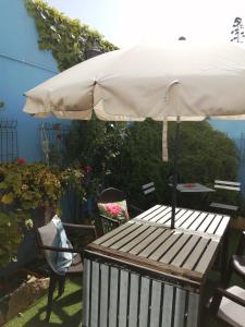 an umbrella sitting on a table with a chair at Peniche Blue Wave Home in Peniche