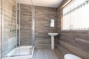 uma casa de banho com um chuveiro, um WC e um lavatório. em Tanzanite - 5 Bedroom House / Sleeps 10 em Coventry