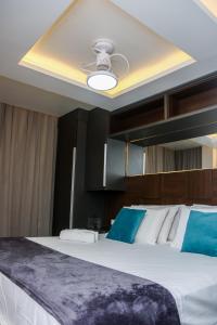 1 dormitorio con 1 cama grande y ventilador de techo en Pousada do Braga, en Cabo Frío