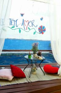 a room with a table and a window with a sign at Ho'oponopono Hostel in Caraguatatuba