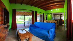 a living room with a blue couch and a table at Cabañas Portal Uritorco in Capilla del Monte