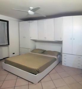 Schlafzimmer mit einem Bett mit weißen Schränken und einer Decke in der Unterkunft white holiday house in Desenzano del Garda