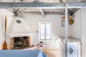 a bedroom with a blue bed and a fireplace at Pefkias Tiny Cottage in Skopelos Town