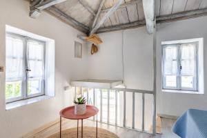 a room with a table and two windows at Pefkias Tiny Cottage in Skopelos Town