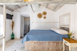 a bedroom with a bed with a blue blanket at Pefkias Tiny Cottage in Skopelos Town