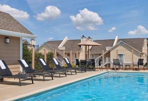 a pool with chaise lounge chairs and a table at AVIA Residences on Savoy in Atlanta