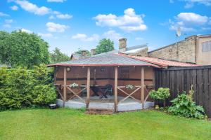 a wooden pavilion with a picnic table in a backyard at Venta in Ventspils