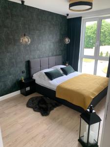 sypialnia z dużym łóżkiem i dużym oknem w obiekcie Castle Apartments Malbork w mieście Malbork