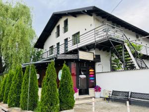 ein weißes Gebäude mit einer Bank davor in der Unterkunft Reny's Studio Apartments -Hiperbara in Livezeni