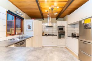 een keuken met witte kasten en een houten plafond bij 42a Alpine Avenue in Hanmer Springs