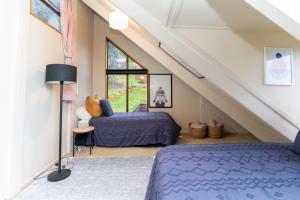een zolderslaapkamer met twee bedden en een raam bij 42a Alpine Avenue in Hanmer Springs