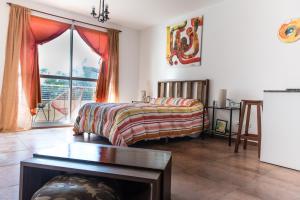 ein Schlafzimmer mit einem Bett und einem großen Fenster in der Unterkunft Naon Arts Experience in Buenos Aires