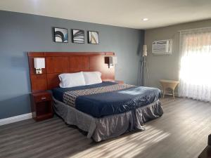 une chambre d'hôtel avec un lit et une fenêtre dans l'établissement Bel Air Motor Hotel, à Tustin