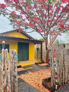 una cerca frente a una casa con un árbol en Chales Barra Grande en Barra Grande