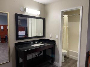 a bathroom with a black sink and a mirror at Bel Air Motor Hotel in Tustin