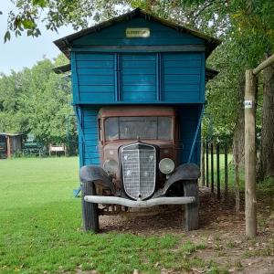 Una vecchia macchina è seduta in un capanno blu di Los furgones de Areco a San Antonio de Areco