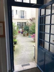 una porta aperta su un cortile con piante in vaso di Superbe appartement proche de la butte Montmartre a Parigi