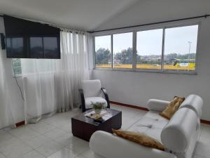 ein Wohnzimmer mit einem Sofa und einem Tisch in der Unterkunft Apartamento oasis del norte in Cali