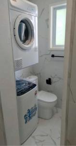 a bathroom with a toilet and a washing machine at AYDIZ APARTMENTS in Nadi +38 photos