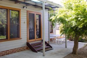 een veranda met een bank op een huis bij Kuzman Homestead in Mudgee