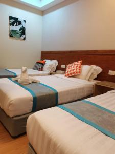 two beds in a room with at TD CAPITAL HOTEL in Inanam