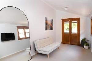 uma sala de estar com uma cadeira e um espelho em Kuzman Homestead em Mudgee