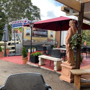 a statue of a woman sitting on a bench in front of a restaurant at Maleny Hills Motel in Maleny