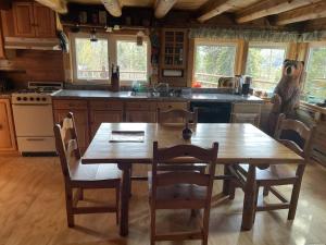 een keuken met een houten tafel en een tafel met stoelen bij Denali Park Homestead in McKinley Park +13 foto's