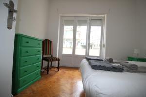 een slaapkamer met een bed, een dressoir en een raam bij WELCOME TO LISBOA in Lissabon
