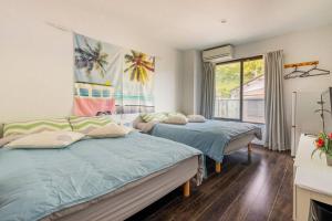 1 dormitorio con 2 camas y ventana en MR. TOMO KAWANA, en Kawana