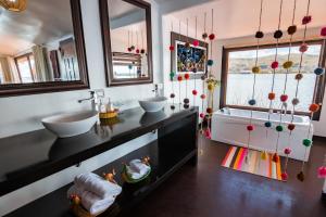 een badkamer met 2 wastafels en een groot raam bij UROS TITICACA LODGE Puno Peru in Puno
