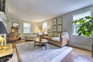 a living room with a couch and a table at Historic Essex Home with Large Yard Near Downtown! in Essex