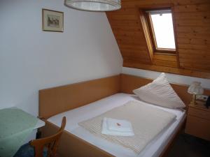 a small bed in a room with a window at Wengerterstube & Gästezimmer Kern in Oberderdingen