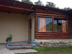 a log cabin with a window on the side of it at barro blanco turismo rural in Villa Achával