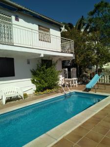 a swimming pool with a slide in front of a building at Cal Jamila in Cubelles