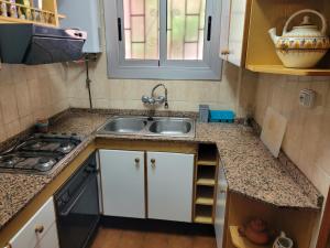 uma pequena cozinha com um lavatório e um fogão em Cal Jamila em Cubelles
