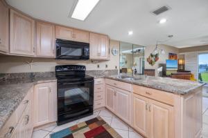 a kitchen with wooden cabinets and a black stove top oven at Point Matanzas B3 in St. Augustine