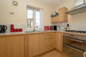 eine Küche mit Spüle und Herd oberen Backofen in der Unterkunft Bristol's Coach House - 2 Bedroom Detached Apartment with Secure Parking in Bristol