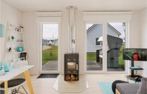 a living room with a fireplace in the center of a house at Sea You in Olpenitz