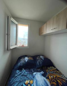 - une chambre avec un lit orné d'un oiseau bleu dans l'établissement LE PANORAMIQUE cap d’agde, au Cap d'Agde