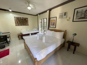 a bedroom with a large bed and a desk and a window at The Duyan House at Sinagtala Resort in Orani