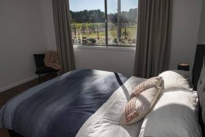 a bedroom with a bed with a large window at CASALE COTTAGE Barossa Valley in Nuriootpa