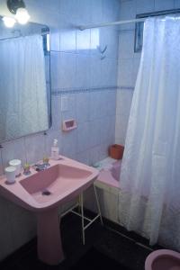 ein Badezimmer mit einem rosa Waschbecken und einer Dusche in der Unterkunft Depto. Alvear 972 in San Salvador de Jujuy